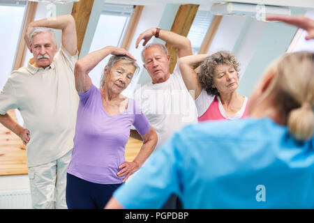 Gruppe von Senioren zu tun stretching Übung im rehab Kurs für Physiotherapie Stockfoto