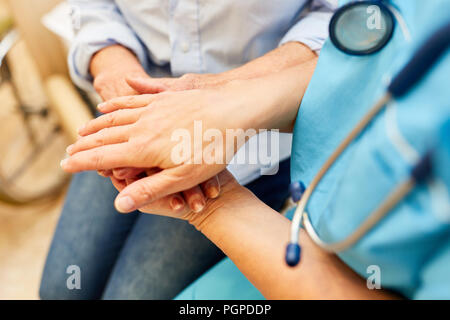 Krankenschwester oder Krankenpfleger hält die Hand eines älteren Bürgers im Pflegeheim Stockfoto