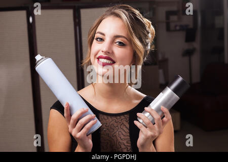 Lächelnd Modell mit zwei haarsprays Stockfoto