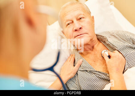 Senior als Patient ist mit dem Stethoskop Atmung zu steuern geprüft Stockfoto