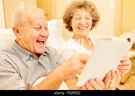 Happy Senioren Paar tut brain-Teaser und Lösen von Kreuzworträtseln Stockfoto