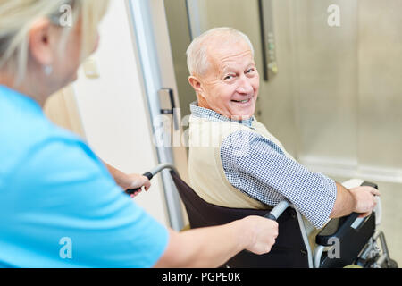 Gerne älterer Mann im Rollstuhl für Pflegepersonal in der Reha betreut werden Stockfoto