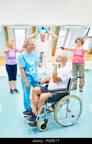 Therapeuten betreut Senioren in der Physiotherapie beim Training mit Hanteln Stockfoto