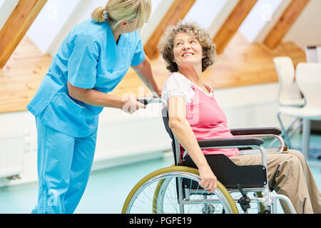 Ältere Frau im Rollstuhl gepflegt, von der Krankenschwester im Ruhestand home Stockfoto