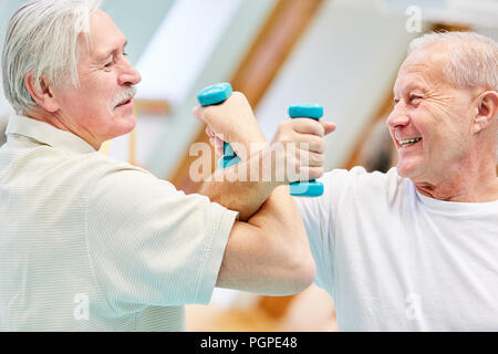 Zwei wesentliche seniors konkurrieren mit Hanteln während der Rehabilitation im Studio Stockfoto