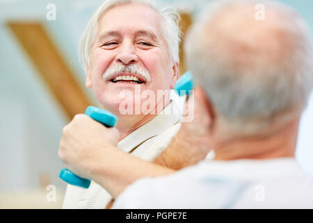 Zwei wesentliche Senioren Spaß haben ihre Stärke messen mit Hanteln während der Rehabilitation Stockfoto