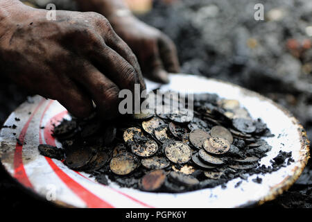 Manila, Philippinen. 28 Aug, 2018. Ein Bewohner sammelt Münzen durch Trümmer nach einem Brand in Manila auf den Philippinen, Aug 28., 2018. Mindestens fünf Kinder sind gefürchtet, Toten und zwei andere wurden verletzt, als eine Reihe von Häusern in Manilas Tondo Bezirk am Montag morgen dem Erdboden gleichgemacht. Credit: rouelle Umali/Xinhua/Alamy leben Nachrichten Stockfoto