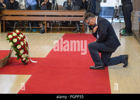 Ramstein-Miesenbach, Deutschland. 28 Aug, 2018. Giancarlo Nutarelli, Bruder des pilot Ivo Nutarelli, dessen Flugzeug in die Menge während der Luftfahrt Katastrophe 1988 abgestürzt, kniete sich in der Kirche während der Service. Vor dreißig Jahren, 70 Menschen starben, als drei italienische Kunstflugstaffel Staffeln krachte in die Air Base und einem brennenden Flugzeug in eine Menschenmenge stürzte. Credit: Oliver Dietze/dpa/Alamy leben Nachrichten Stockfoto