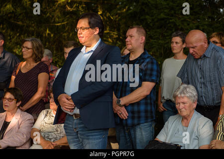 Ramstein-Miesenbach, Deutschland. 28 Aug, 2018. Marc-David Jung, der schwere Verbrennungen erlitten, wie ein vier Jahre alter Junge, steht 30 Jahre nach dem Unfall zusammen mit anderen Betroffenen und Angehörigen der Opfer am Gedenkstein für die Ramstein Air Disaster. 1988, 70 Menschen starben, als drei Maschinen einer italienischen Kunstflugstaffel zusammengestossen und Geschwader ein brennendes Flugzeug stürzte in eine Menschenmenge. Credit: Oliver Dietze/dpa/Alamy leben Nachrichten Stockfoto