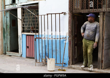 Havanna, Kuba. 17. Jan 2014. Ein Bauarbeiter eine Auszeit nimmt und raucht eine Zigarette, als der Mann, der nebenan wohnt auf seinem Fenster in Havanna. Hat sich nicht viel für die Mittelklasse von Kuba verändert. Sie leben noch in einer isolierten, Regierung, die kommunistische Gesellschaft. Während einige wenige neue, moderne Annehmlichkeiten wie WLAN haben ihren Weg nach Kuba die meisten Kubaner nicht leisten, es regelmäßig zu verwenden. Credit: Allison Abendessen/ZUMA Draht/Alamy leben Nachrichten Stockfoto