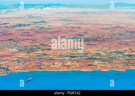 Blick auf die Insel Zypern in der Region der Bucht von Dhekelia. Fragment eines Power Station, ein Dock, eine Villa und ein Dorf, eine Straße und eine mounta Stockfoto