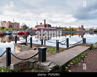 Stein alten historischen Pier mit Ketten auf Metall Spalten, mit Stein Schritte mit Blick auf das antike Gebäude der verlassenen Fabrik Manufaktur, Orthod Stockfoto