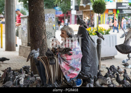 Frau füttern viele Tauben in der inneren Stadt Straße, Sofia, Bulgarien Stockfoto