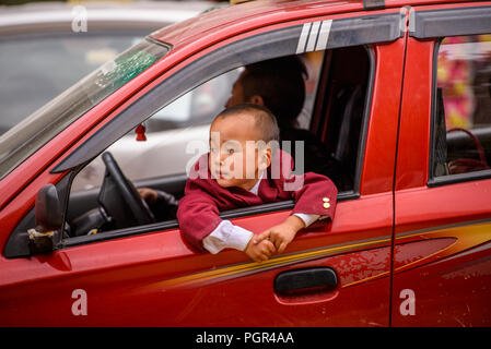 SIKKIM, INDIEN - Mar 13, 2017: Unbekannter Indischer kleiner Junge schaut aus dem roten Auto. Stockfoto