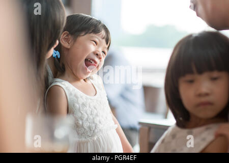 Candid Schießen von Menschen in der Cafeteria. Kleines Mädchen mit verschiedenen Gesichts Ausdruck. Asiatische Familie Lebensstil im Freien mit natürlichem Licht. Stockfoto