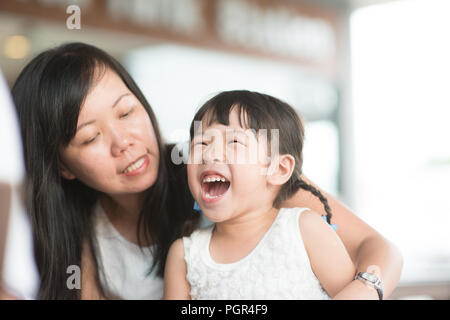 Candid Schießen von Menschen in der Cafeteria. Kleines Mädchen mit verschiedenen Gesichts Ausdruck. Asiatische Familie Lebensstil im Freien mit natürlichem Licht. Stockfoto