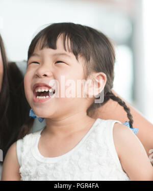 Candid Schießen von Menschen in der Cafeteria. Kleines Mädchen mit verschiedenen Gesichts Ausdruck. Asiatische Familie Lebensstil im Freien mit natürlichem Licht. Stockfoto