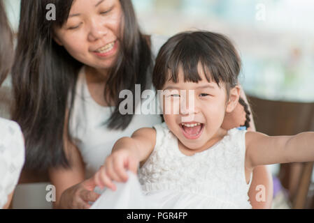 Candid Schießen von Menschen in der Cafeteria. Kleines Mädchen mit verschiedenen Gesichts Ausdruck. Asiatische Familie Lebensstil im Freien mit natürlichem Licht. Stockfoto