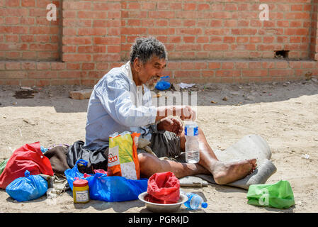KATMANDU, Nepal - Mar 6, 2017: Unbekannter Chhetri grauhaariger Mann sitzt auf dem Boden und hält eine Plastikflasche mit Wasser. Chhetris ist die meisten Pop Stockfoto