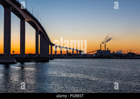 Sonnenuntergang hinter der Industrie und der massiven Jordanien Brücke in Chesapeake Virginia Stockfoto