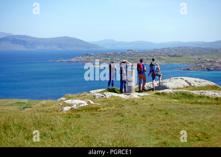 Menschen mit Blick auf die spektakuläre Aussicht auf Mull vom Gipfel des Dun ICH, dem höchsten Punkt auf Iona im Inneren Hebriden von Schottland Stockfoto