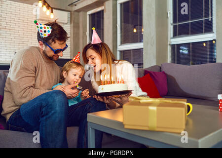 Glückliche Familie mit einem festlichen Kuchen feiert Geburtstag Stockfoto