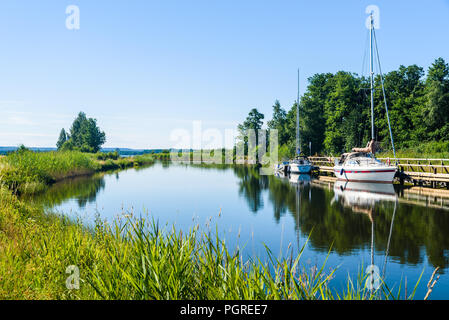 Die Gota Canal an Tatorp, Schweden, an einem sonnigen Sommertag. Segelboote von der Pier. Stockfoto