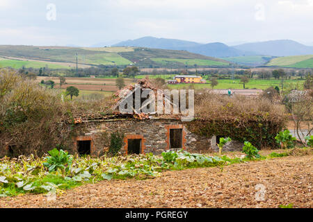 Kleine ländliche Haus mit grünen Hügeln im Hintergrund in Asturien, Spanien Stockfoto