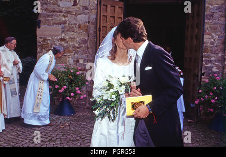 Das Brautpaar Andreas Augst von Habsburg Lothringen und Maria Christina von Hatzfeld Dönhoff beim Hochzeitskuss in Johannisberg, Deutschland 1994. Brautpaar Andreas August von Habsburg Lothringen und Maria Christine von Hatzfeld Doenhoff genommen Küssen am Johannisberg, Deutschland 1994. Stockfoto