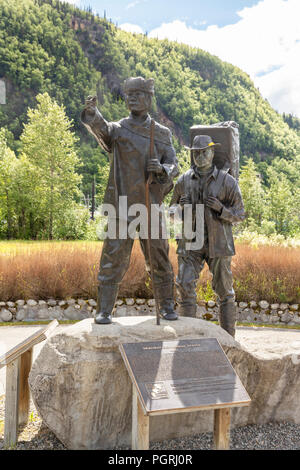 Die skagway Centennial Statue von Chuck Buchanan zeigt eine typische Prospector zur Zeit des Klondike Gold Rush von einem Muttersprachler Tlingit Guide geführt wird Stockfoto