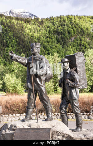 Die skagway Centennial Statue von Chuck Buchanan zeigt eine typische Prospector zur Zeit des Klondike Gold Rush von einem Muttersprachler Tlingit Guide geführt wird Stockfoto