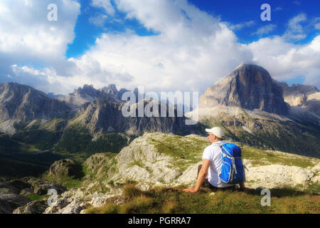 In der wunderschönen alpinen Landschaft eingebettet, ein Mann bewundert die hochalpine Landschaft mit Bergen und bewölktem Himmel. Stockfoto