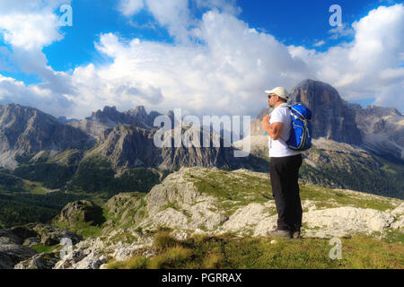 In der wunderschönen alpinen Landschaft eingebettet, ein Mann bewundert die hochalpine Landschaft mit Bergen und bewölktem Himmel. Stockfoto