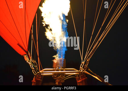Makroaufnahme eines Heißluftballons Brenner vor schwarzem Hintergrund, Heißluftballon mit einem gelben Feuer von einem Brenner bei Nacht Stockfoto