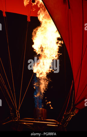 Nahaufnahme eines Brenners von einem Heißluftballon mit lodernde Flammen, Heißluftballon mit einem gelben Feuer von einem Brenner bei Nacht Stockfoto