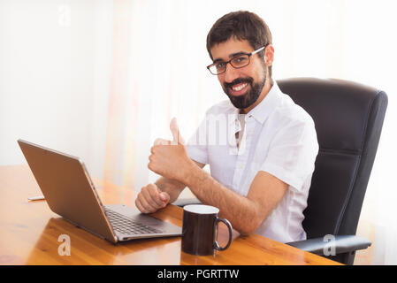 Glückliche junge bärtiger Mann im Büro arbeiten Stockfoto