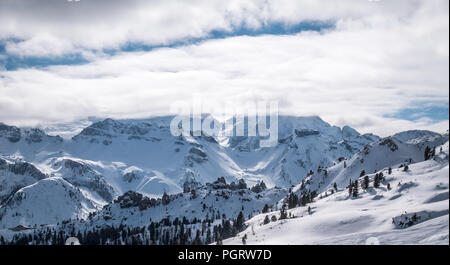 Panorama über verschneite Berge in den Alpen. Winterlandschaft. Niedrige Wolken oder Myst ist für die oben in den Bergen. Stockfoto