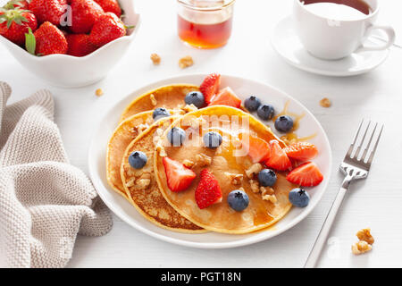 Pfannkuchen mit Heidelbeeren Erdbeere Honig und Nüssen für Frühstück Stockfoto