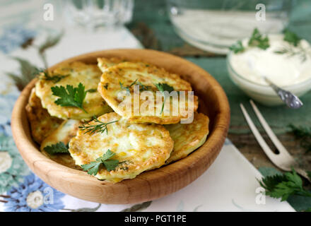 Pfannkuchen mit Zucchini und Mais, serviert mit saurer Sahne, Petersilie und Dill. Vegetarisches Essen, selektiven Fokus. Stockfoto