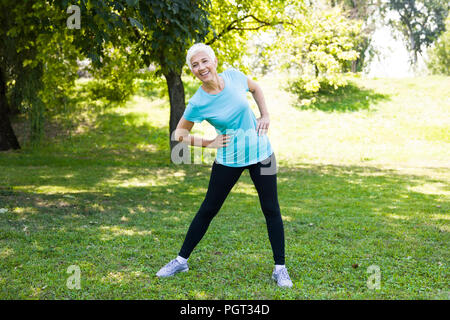 Portrait der älteren Frau, streching Übungen im Park Stockfoto