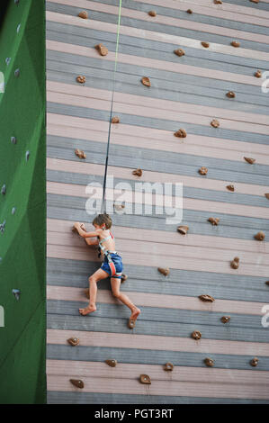 Little Boy bis Klettern am Spielplatz brave im Freien Sport Freizeit Stockfoto