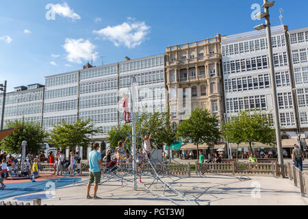 Kinder auf dem Spielplatz in der Avenida La Marina mit ihren typischen Glas Balkone und die La Marina Park, Parque La Marina, A Coruña, Galizien, Spanien Stockfoto