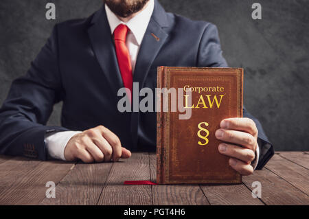 Rechtsanwalt zeigt Satzung Buch des Gesetzes in Unternehmen. Stockfoto