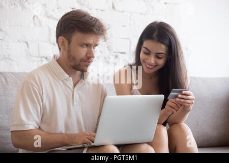 Die jungen Eheleute, die online einkaufen zu Hause Stockfoto