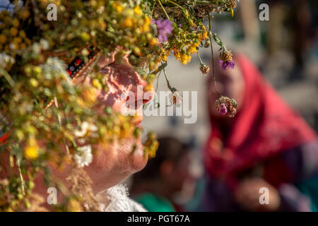 Mädchen in Russischen sarafans und mit Blumenkranz auf dem Kopf während einer Village Holiday Stockfoto