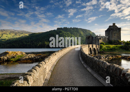 Am Abend licht auf die neue stone arch Fußgängerbrücke mit dem restaurierten Eilean Donan Castle auf der Insel an drei Seen in den schottischen Highlands Schottland Großbritannien Stockfoto