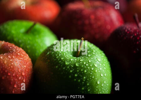 Granny Smith und Red Delicious äpfel mit Wassertropfen und dunkle Schatten Stockfoto