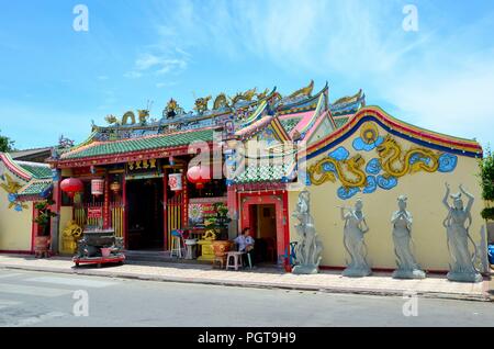 Frau sitzt außerhalb der chinesischen Tempel mit Urne und Gottheit Statuen Pattani Thailand Stockfoto