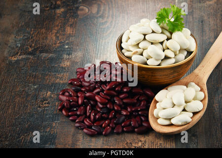 Komposition mit Schüssel mit Bohnen auf Holztisch. Stockfoto