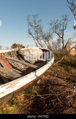 Alte hölzerne Beiboot Ruderboot Strände auf Gras aus der Nähe gesehen auf der Bug mit Detail der Rumpf vor blauem Himmel Stockfoto